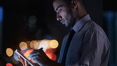 Man using tablet at night